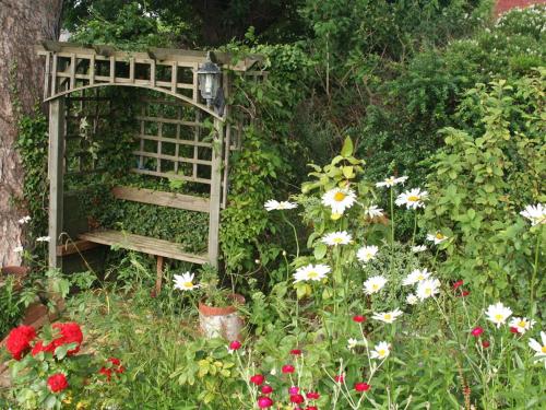a garden with a bench and some flowers at Glan Heulog Guest House in Conwy
