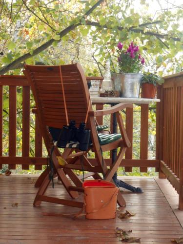 a rocking chair sitting on a deck with a table at Casa sull'Albero Aromantica in San Salvatore Monferrato