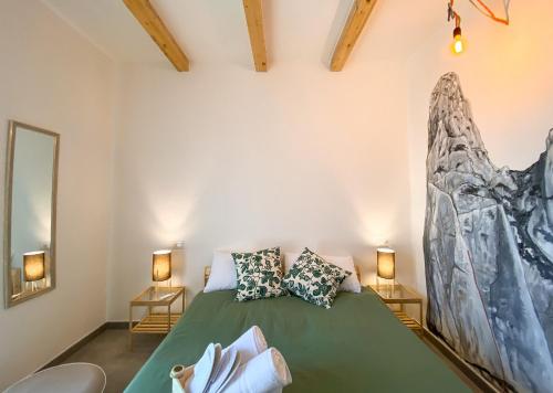 a bedroom with a green bed with two lamps at bedandclimbing in Baunei