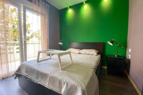 um quarto verde com uma cama com uma parede verde em Green apartment with view em Komotini