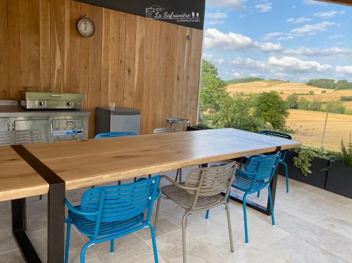 une cuisine avec une grande table et des chaises en bois dans l'établissement La Safranière, à Lagraulet-Saint-Nicolas