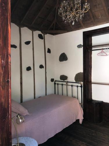a bedroom with a bed with rocks on the wall at Casa MARIA in Tazacorte
