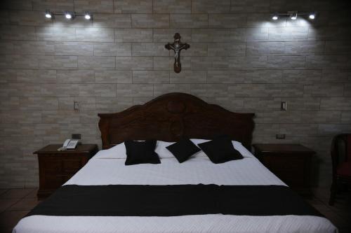 a bedroom with a bed with black and white pillows at Hotel Posada Santa Fe Sabinas in Sabinas