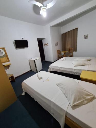 a hotel room with two beds and a tv at VITORIA GARDEN in Águas de Lindóia