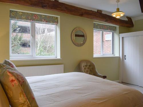 1 dormitorio con 1 cama grande y 2 ventanas en Lovely old cottage, en Stratford-upon-Avon
