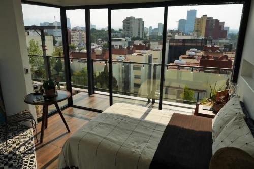 a bedroom with a bed and a view of a city at Loft REMEDIOS - penthouse CDMX - áreas comunes compartidas in Mexico City