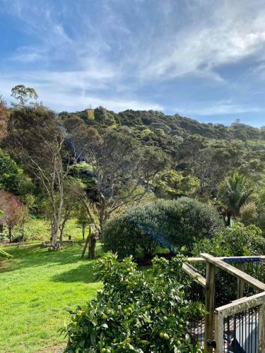 a view of a mountain with trees and a fence at Waiheke Island Guesthouse in Ostend