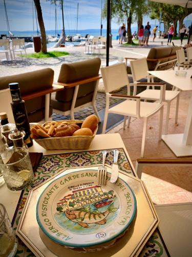 a table with a plate and a basket of bread at Albergo Gardesana in Torri del Benaco