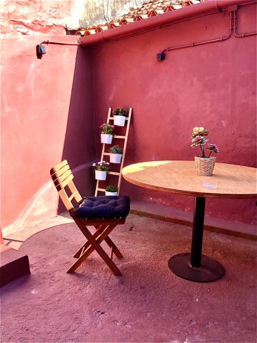 a table and a chair next to a table with potted plants at Arrábida House in Porto