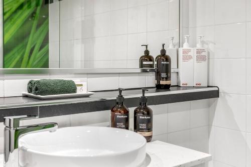 a bathroom with a sink and bottles of wine at Berry Village Boutique Motel in Berry