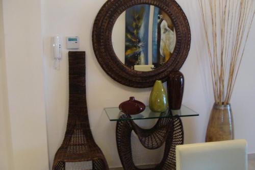 a mirror on a wall next to a shelf with vases at Polyxenia Isaak Luxury Villas and Apartments in Protaras
