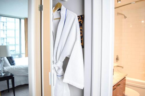 a bathroom with a white robe hanging on a door at Vancouver Extended Stay in Vancouver