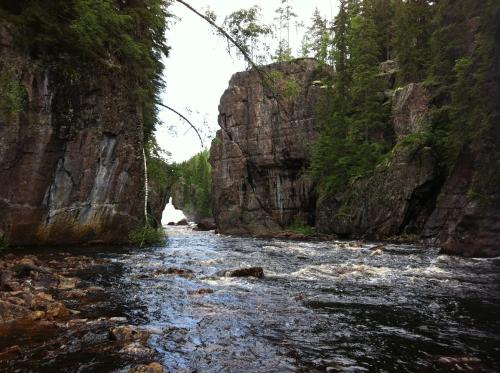a river between two large rocks in a canyon at Prinsgården B&B rum stugor in Mora