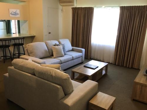 a living room with a couch and a coffee table at Sandcastles Holiday Apartments in Coffs Harbour