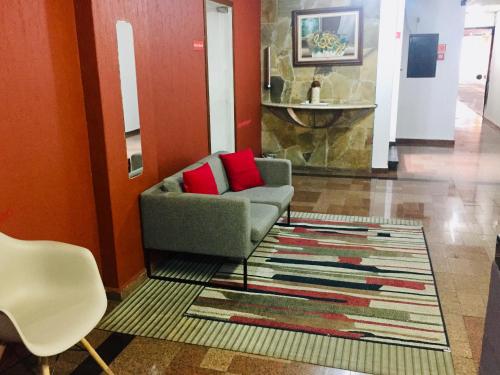 ein Wohnzimmer mit einem Sofa und einem Teppich in der Unterkunft Hotel Cambará - By UP Hotel in Osasco