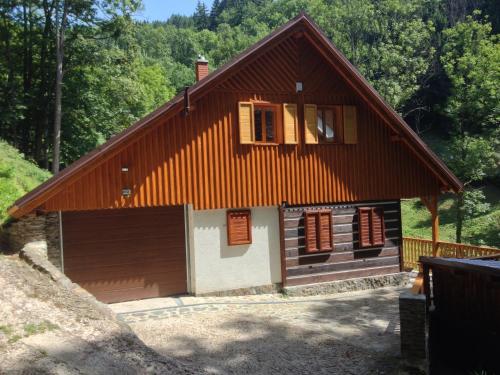 una pequeña casa con techo marrón y garaje en Chata Hokejka, en Rokytnice nad Jizerou