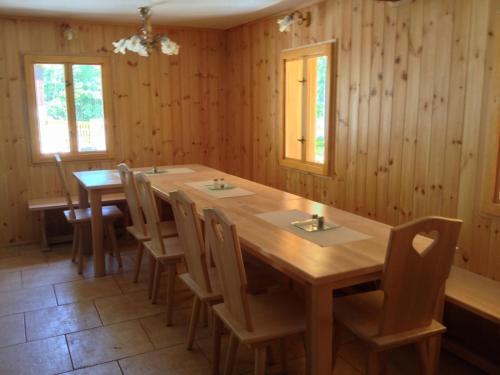 Un comedor con mesa y sillas de madera. en Chata Hokejka, en Rokytnice nad Jizerou