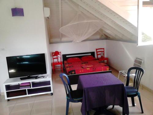 um quarto com uma mesa, uma cama e uma televisão em STUDIO 2- Laurier - 4 pers - proche centre em Terre-de-Haut