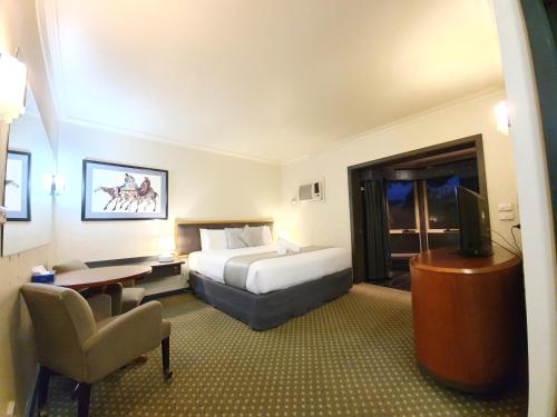 ein Hotelzimmer mit einem Bett und einem Fernseher in der Unterkunft Bell Motel in Melbourne