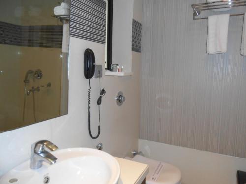 a bathroom with a shower and a sink and a toilet at Southern Plaza in Kolkata