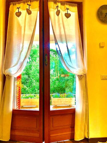 a pair of windows with white curtains on them at Il Bosco Guest House Subiaco in Subiaco