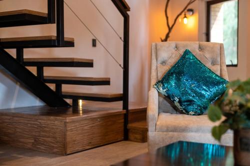 a blue pillow sitting on a chair next to a staircase at Villa Toscana ValQuirico Lofts & Suites Hotel Boutique in Santeagueda