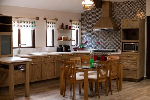 a kitchen with wooden cabinets and a table and chairs at Villa Toscana ValQuirico Lofts & Suites Hotel Boutique in Santeagueda