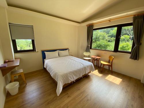 - une chambre avec un lit et 2 fenêtres dans l'établissement 南庄拾光民宿, à Nanzhuang