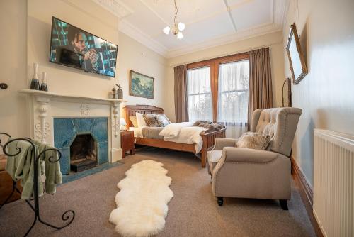 バルクルーサにあるThe Fern & Thistle Luxury Accommodation- Drinks, Hotpool, Saunaのソファと暖炉のあるリビングルーム