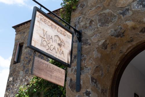 a sign on the side of a stone building at Villa Toscana ValQuirico Lofts & Suites Hotel Boutique in Santeagueda