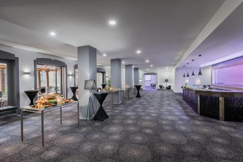 a large room with tables and a large screen at Sydney Central Hotel managed by The Ascott Limited in Sydney