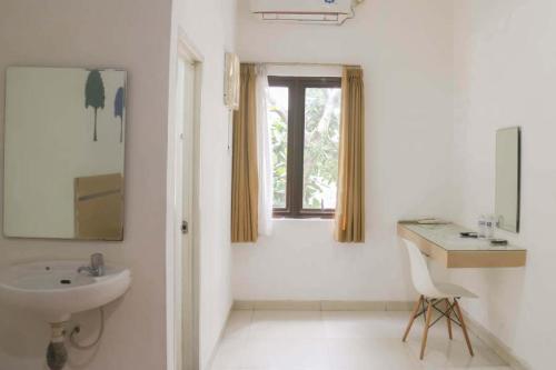 a white bathroom with a sink and a window at RedDoorz near Alun Alun Bandung 3 in Bandung