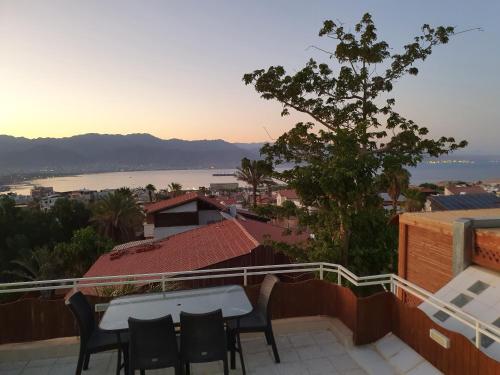 eine Terrasse mit einem Tisch und Stühlen auf dem Balkon in der Unterkunft Shefer Guesthouse in Eilat