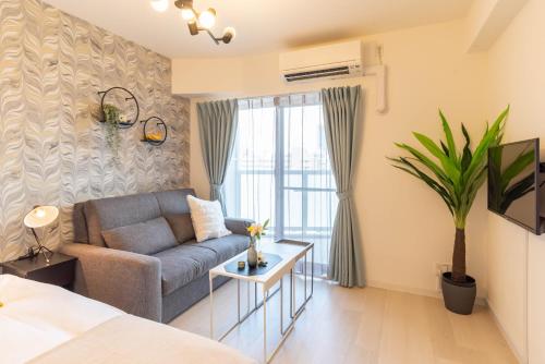 Bijou Suites Lieto APM في أوساكا: غرفة معيشة مع أريكة وطاولة
