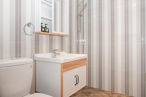 a bathroom with a sink and a toilet and a mirror at EasyLiving in Tainan