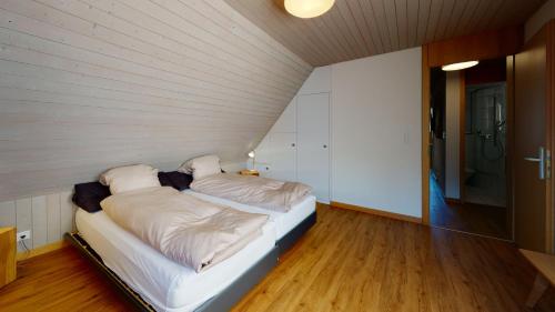 a bed with two pillows on it in a room at Reka-Feriendorf Wildhaus in Wildhaus