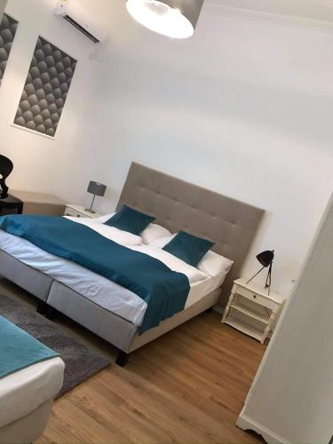 a bedroom with a large bed with blue pillows at Villa Campana in Siófok
