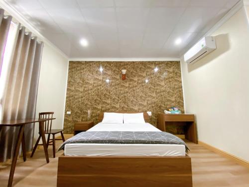 sypialnia z łóżkiem w pokoju ze ścianą w obiekcie Đình Vũ 3 w Hajfong