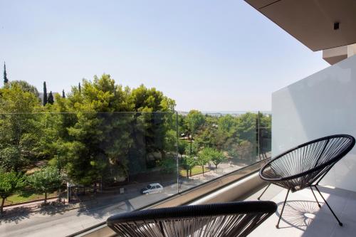 two chairs on a balcony looking out at a street at Athens Panorama Project in Athens