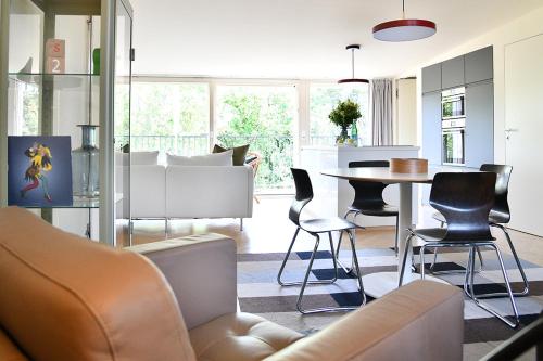 - un salon avec un canapé, une table et des chaises dans l'établissement JETHON Exklusives City-Appartement Bernburg, à Bernburg