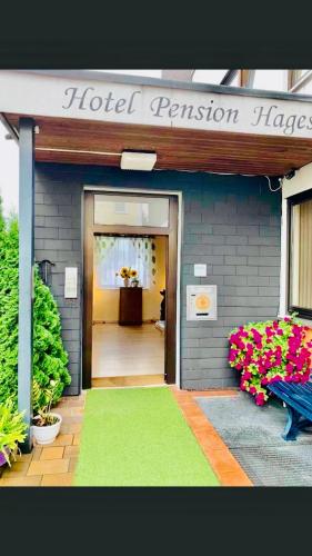 a hotel entrance with a green rug in front of a building at Hotel Hages in Bad Salzuflen