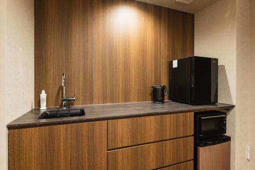 a kitchen with a sink and a microwave at GRAND BASE Hakatamon in Fukuoka