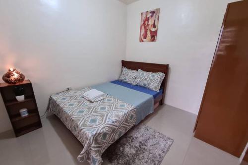 a small bedroom with a bed and a night stand at Cozy Space Near SM with Netflix and Fiber WiFi in Batangas City