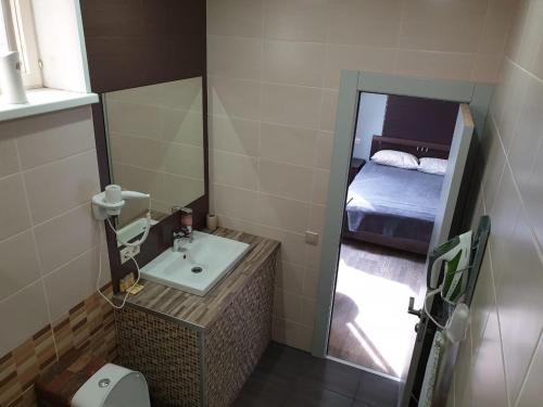 een kleine badkamer met een wastafel en een spiegel bij Hostel Ester House in Moskou