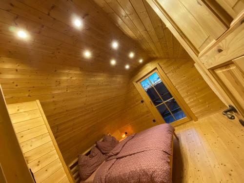 a bedroom in a log cabin with a bed in it at Loghouse Brunka - Escape from life on a highway in Gornja Radgona
