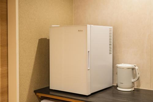 a white refrigerator sitting on top of a counter at GRAND BASE Hakatamon in Fukuoka