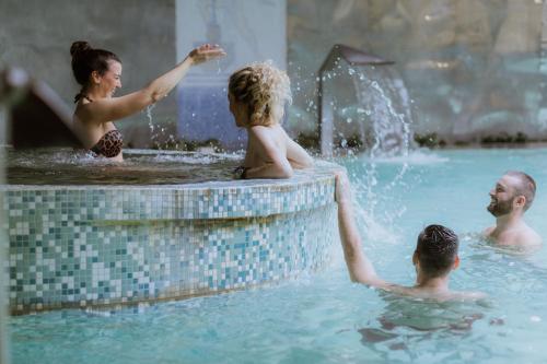 a group of people in a pool with a fountain at Medical and Spa Centre Merkur in Vrnjačka Banja