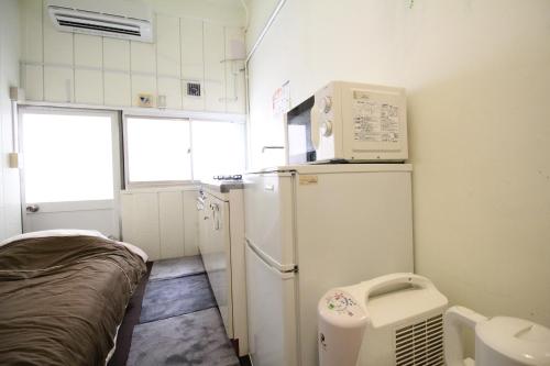 Una pequeña cocina con nevera y fregadero. en Azami 7 Miyakojima, en Isla Miyako