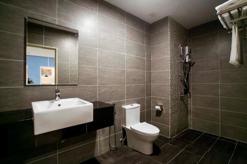 La salle de bains est pourvue d'un lavabo blanc et de toilettes. dans l'établissement Aurora Pavilion Bukit Jalil by Ody Suites, à Kuala Lumpur