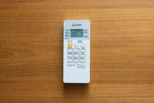 a remote control sitting on top of a wooden table at GRAND BASE HAKATA-I in Fukuoka